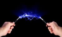 Hands holding cables with blue electrical arc