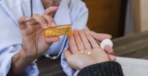 close up elderly female doctor in white coat administering medication