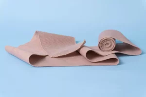 A roll of brown bandage on a blue surface, perfect for dressing wounds