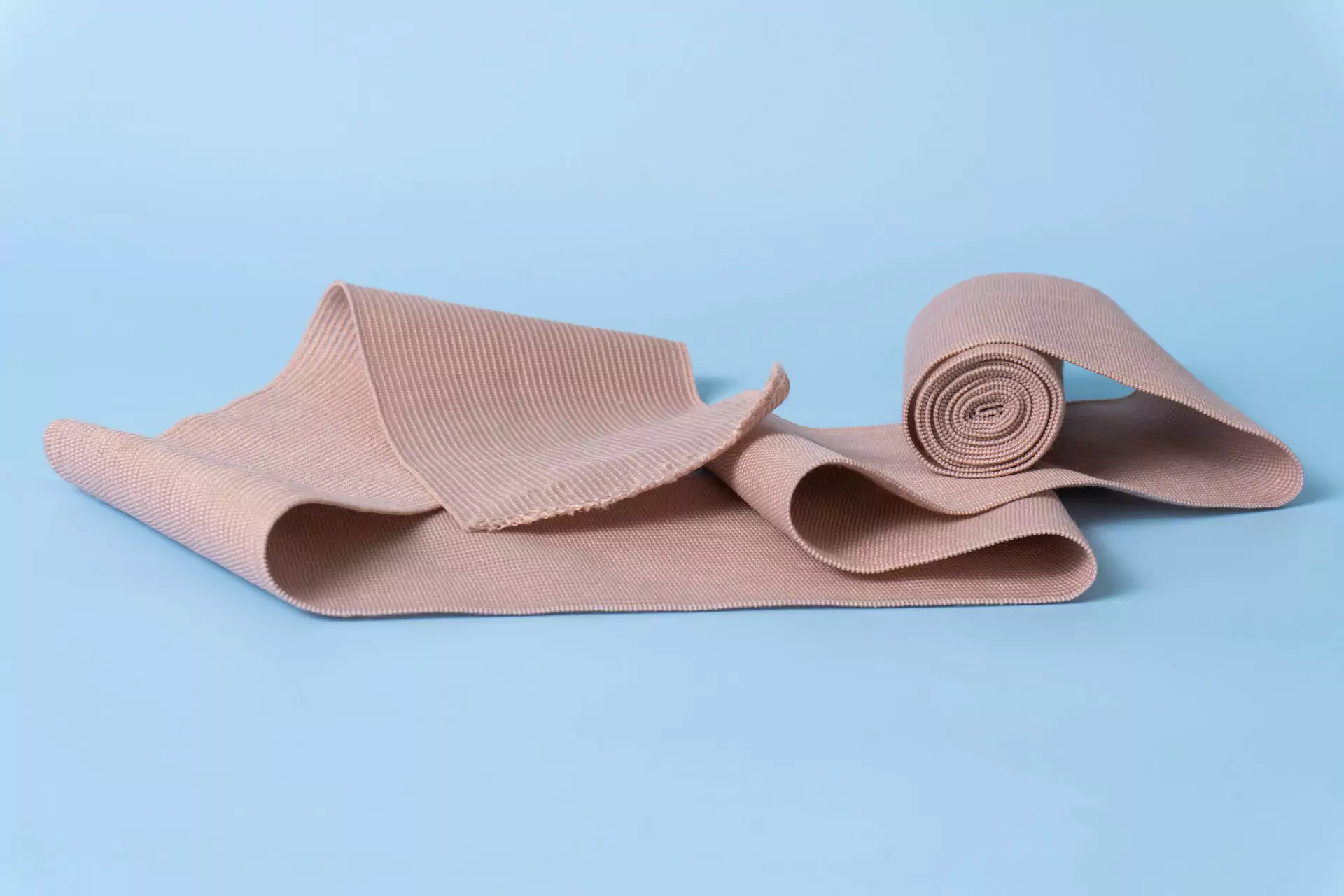 A roll of brown bandage on a blue surface, perfect for dressing wounds