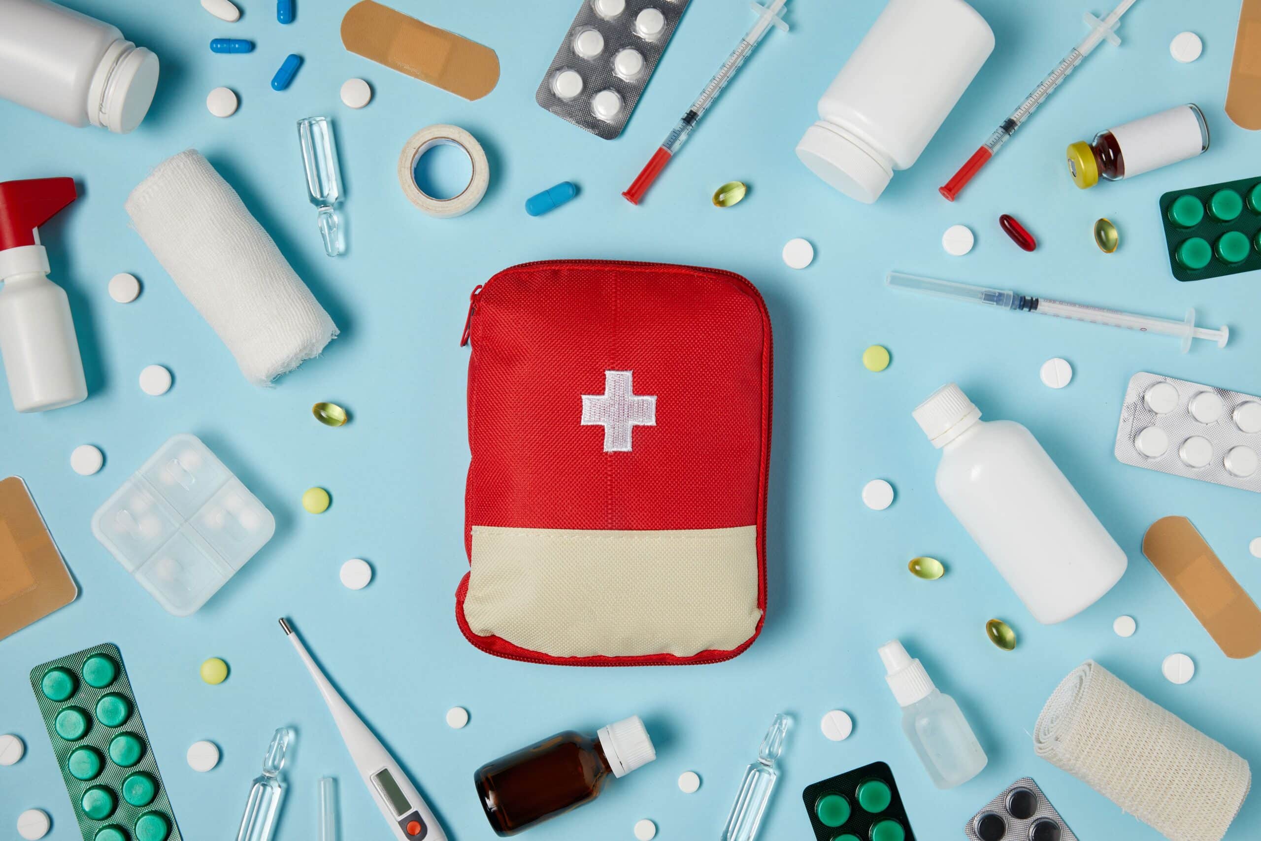 top view of red first aid kit bag on blue surface.