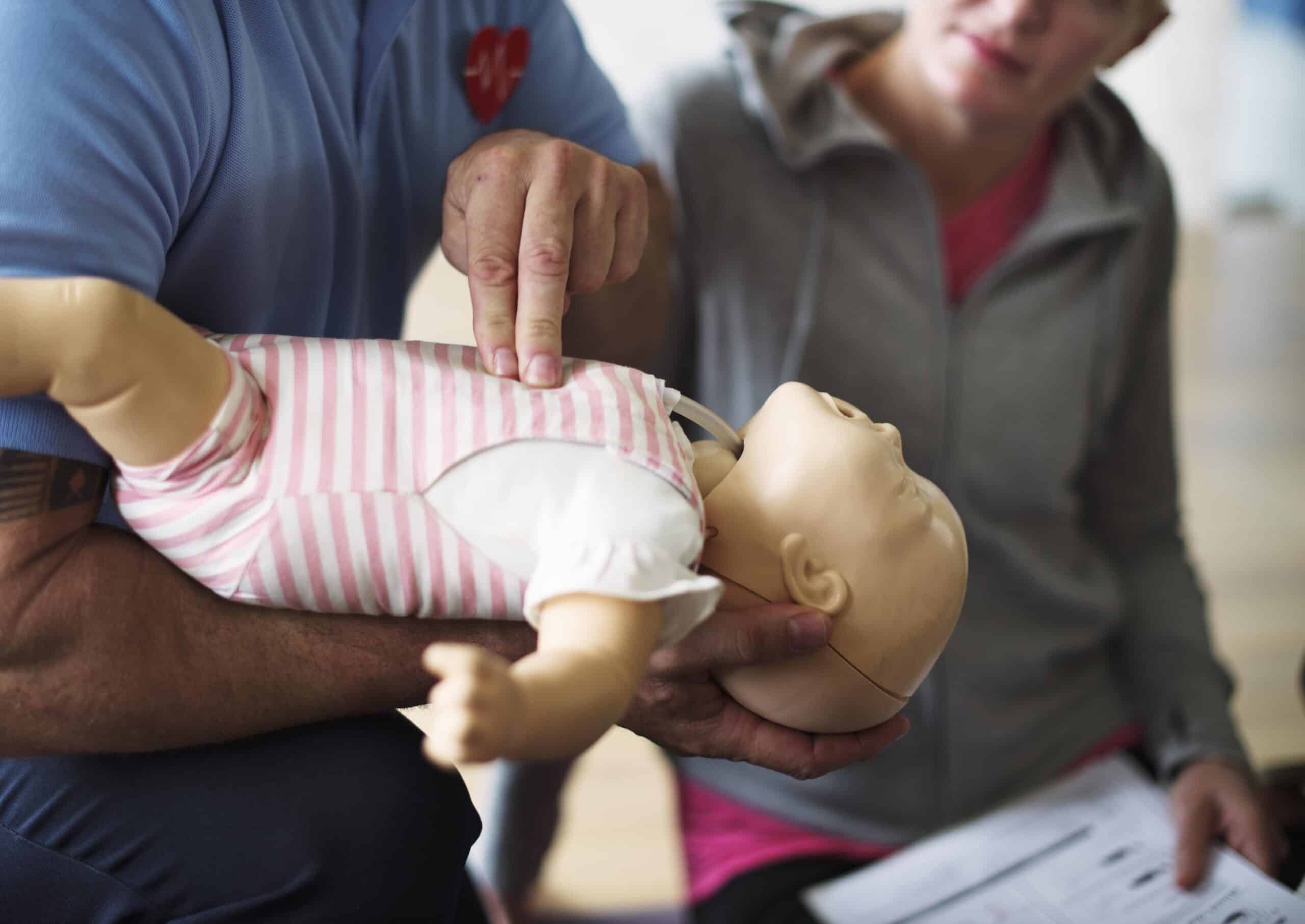 CPR first aid training on a doll infant