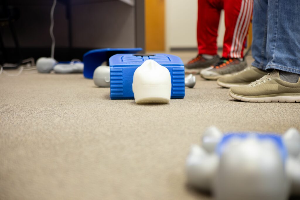 A staff near the AED machine to practice first aid recovery treatment on a dummy doll