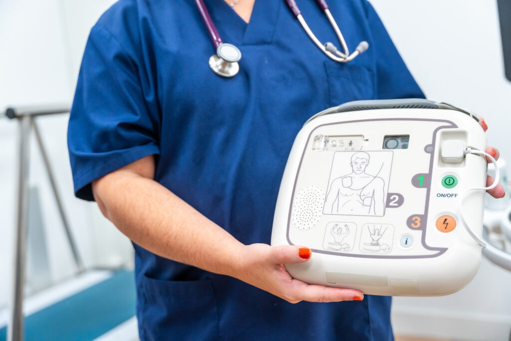 Cardiologist holding a defibrillator (AED) and explain how to use it