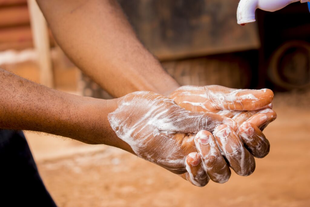 Hand of a male washing his hands with water and soap