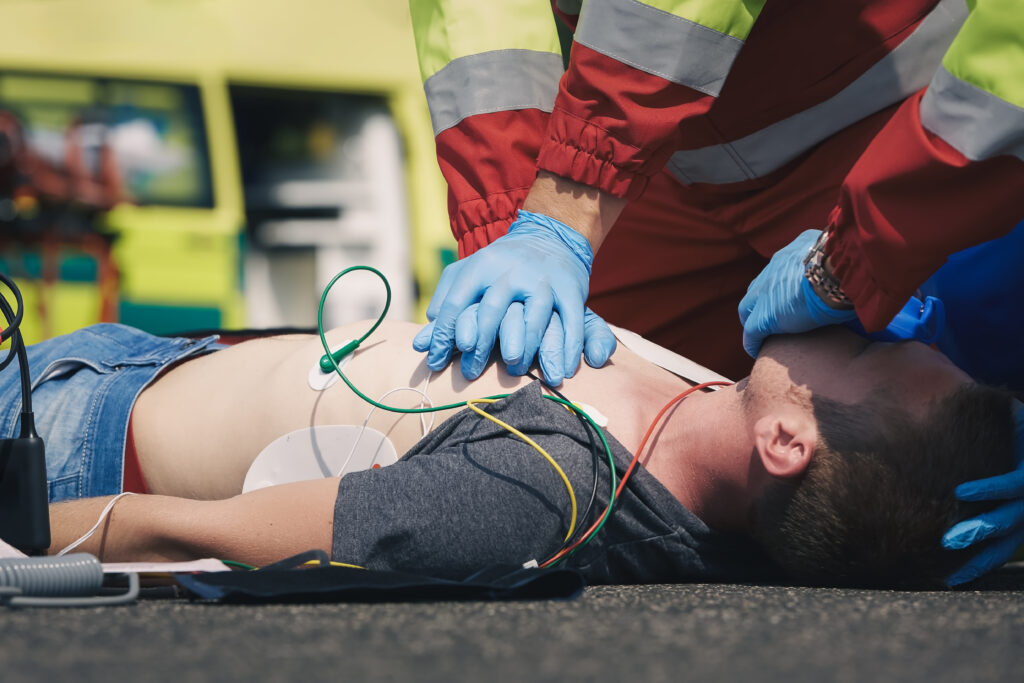 Hands of paramedic and doctor of emergency service during resuscitation on road