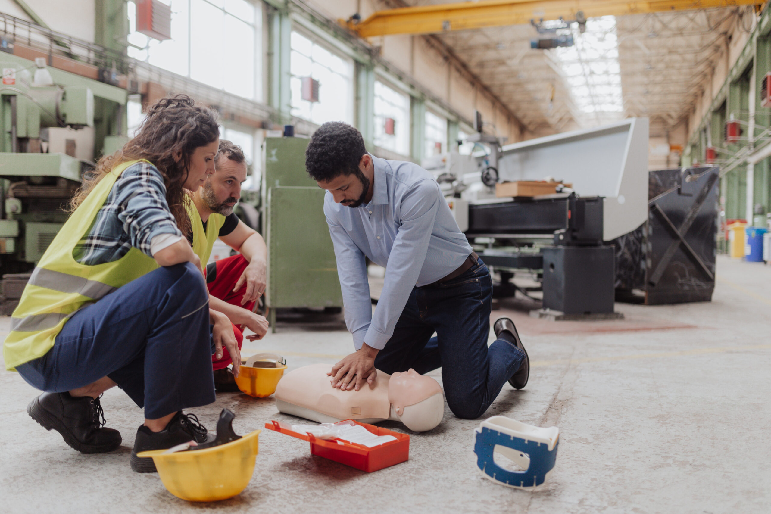 Male instructor showing first medical aid on doll during workplace first aid certification