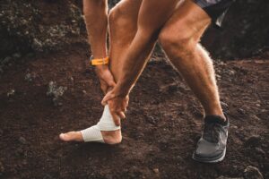 Male runner holding injured leg close up and suffering with pain from sprains and strains