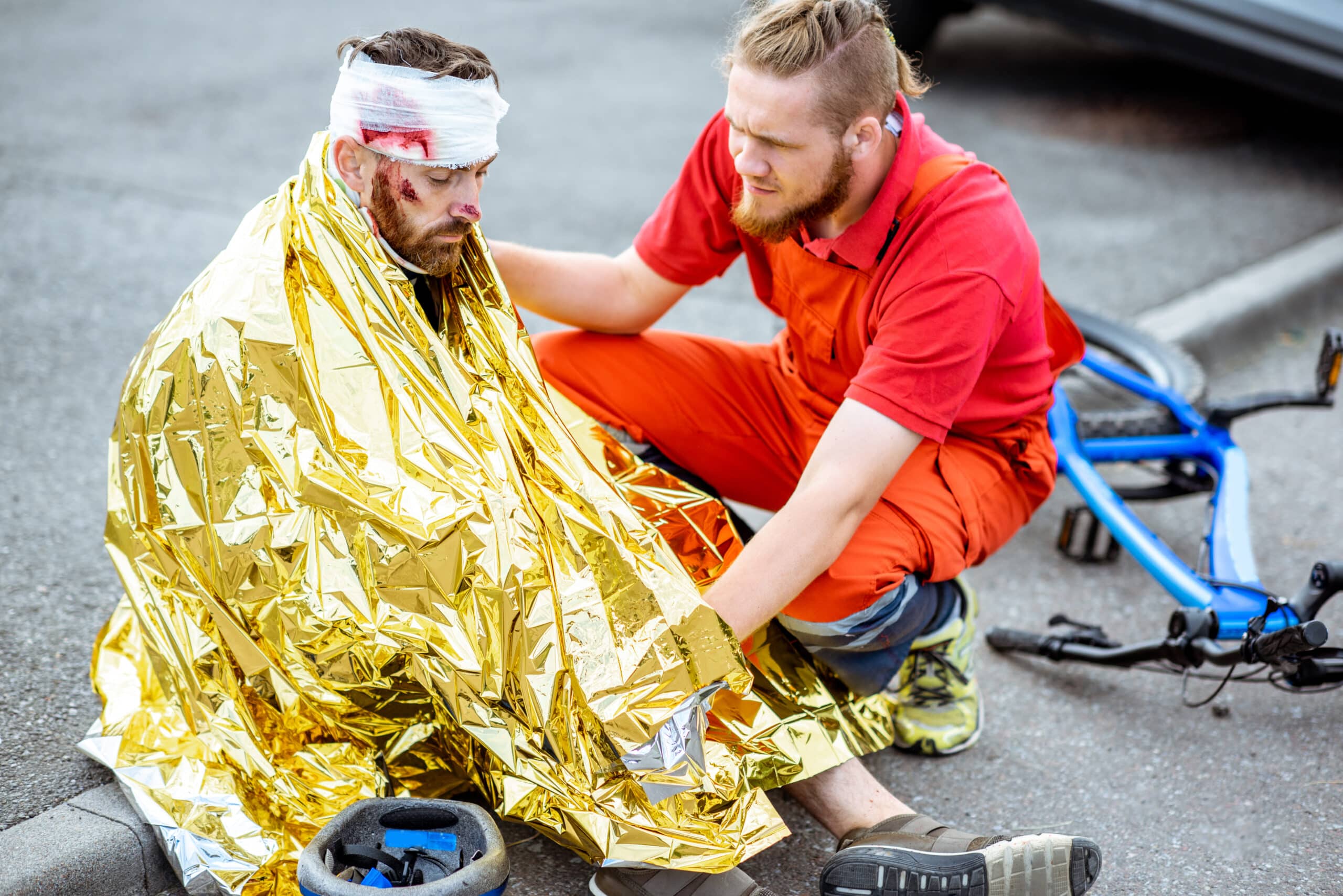 Medic covering victim with thermal blanket after the accident
