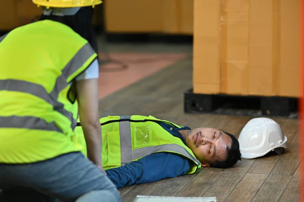 a man lying on the floor with a safety vest