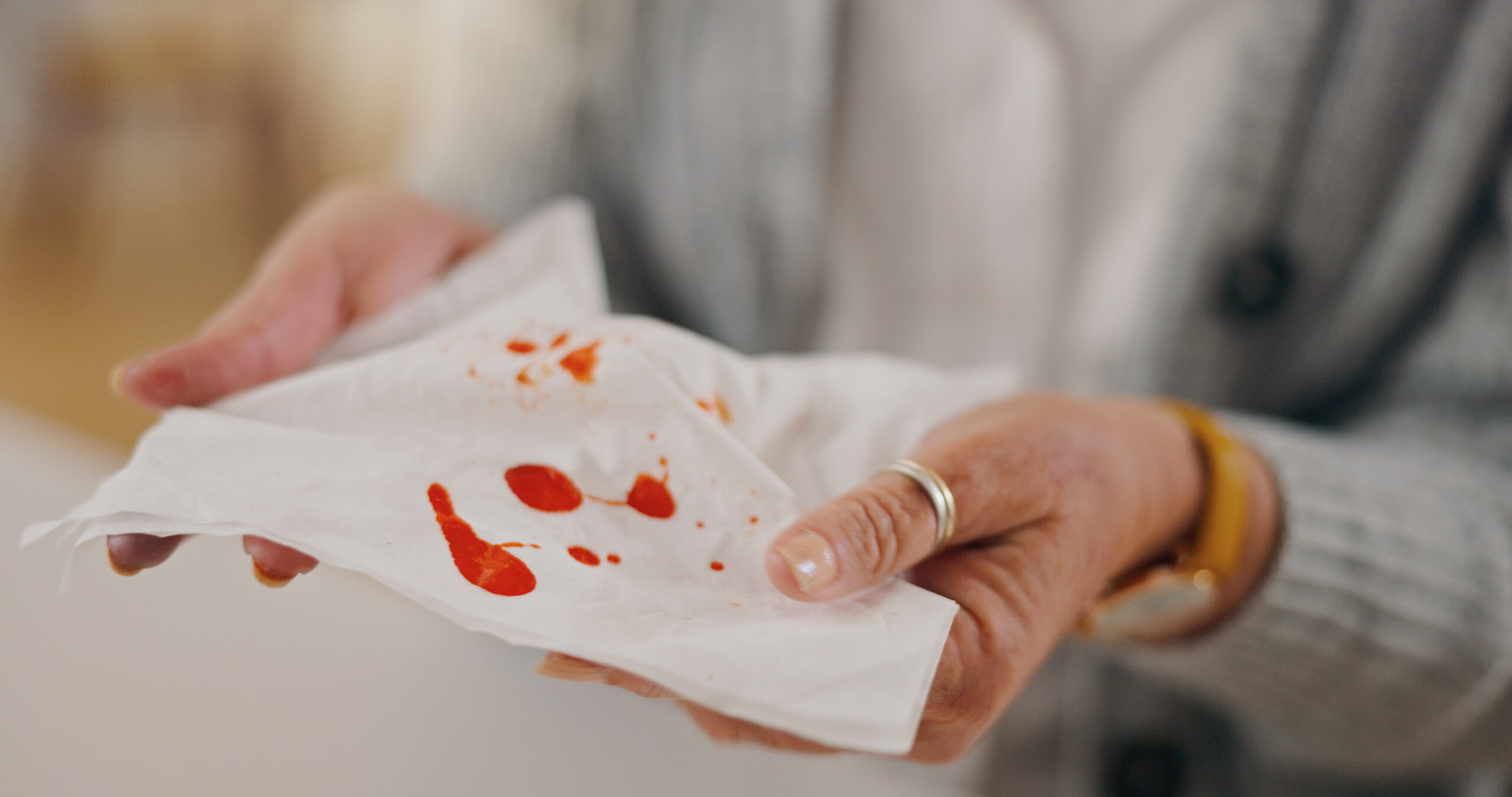 woman hands and tissue with blood in home