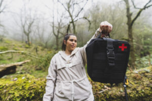 holding a remote first aid bag in the forest