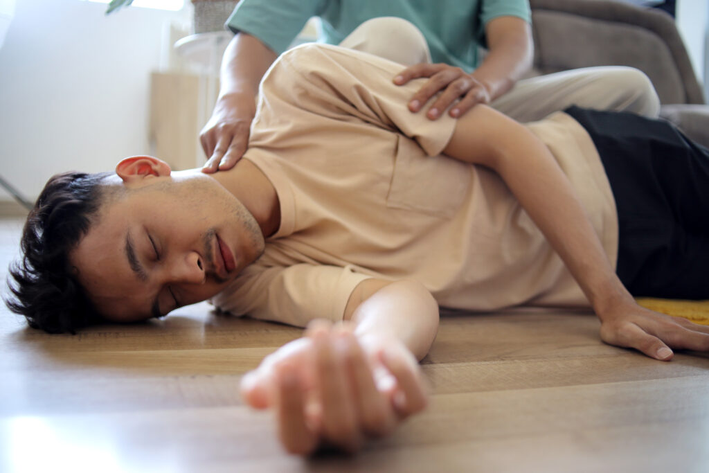 man-doing-cpr-first-aid-checking-pulse-to-asian