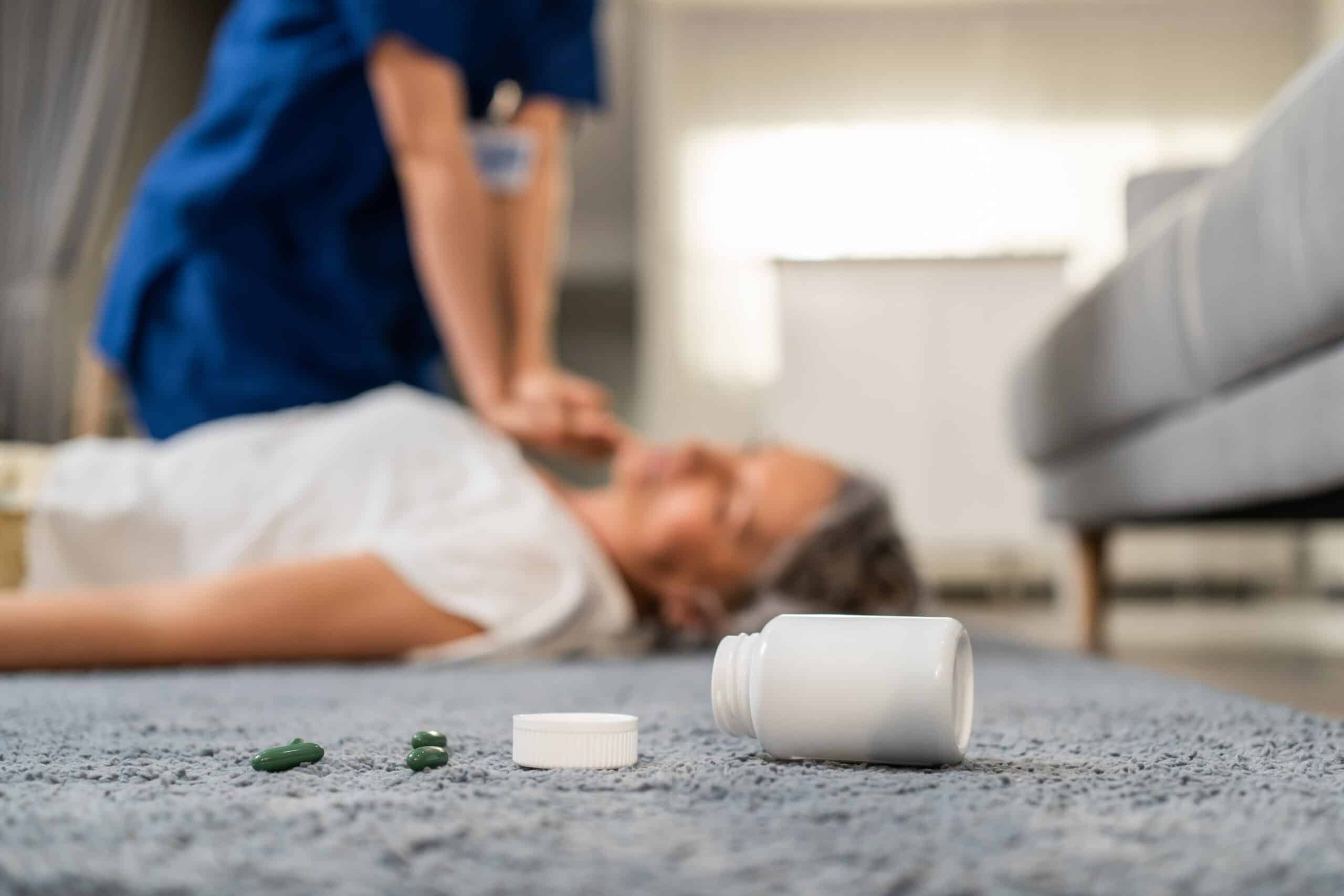 Asian caregiver saving senior woman's life by doing cpr in emergency. Attractive young female carer doctor doing first aid, heart massage to unconscious patient with heart attack in living room at hom