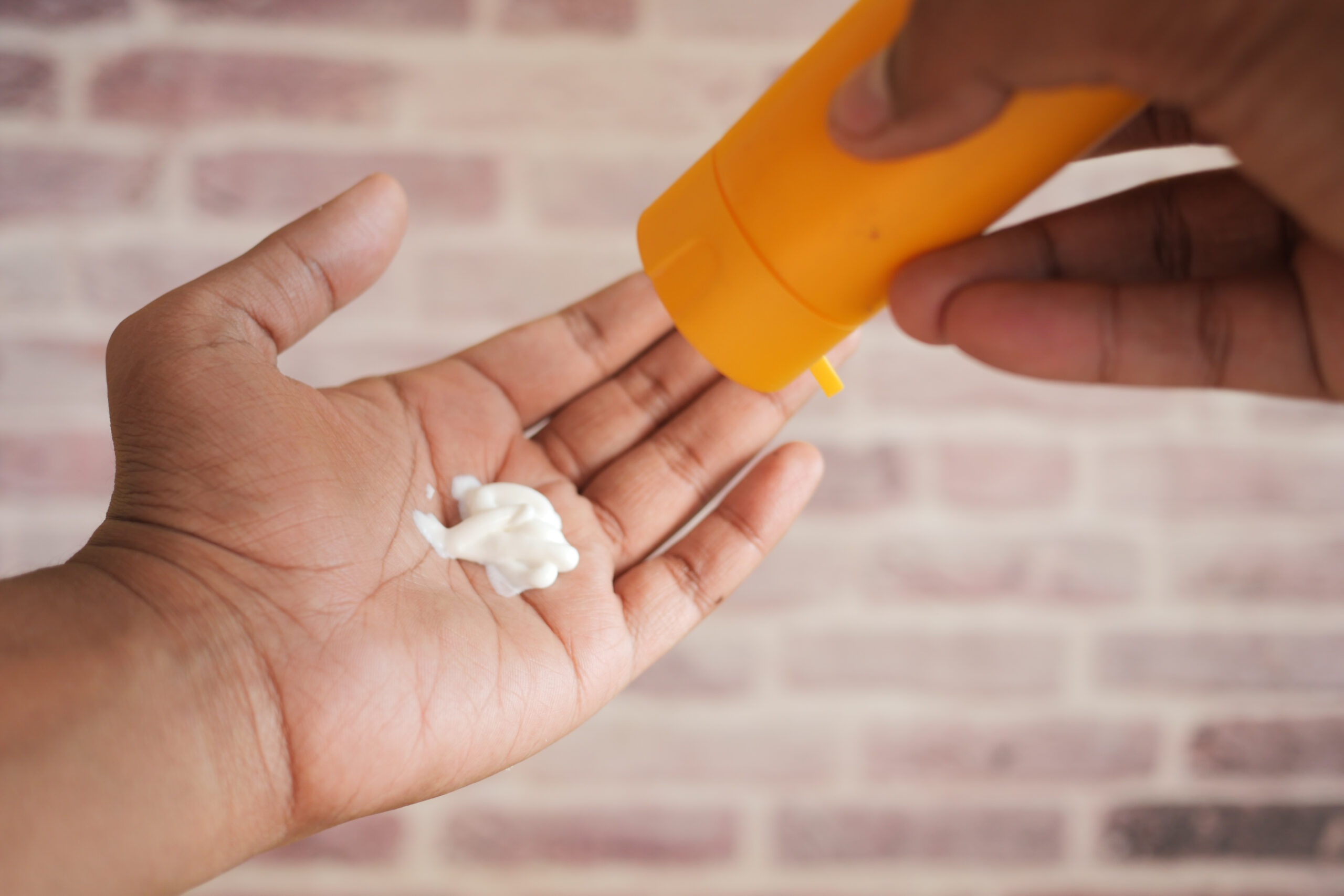 young men using sunscreen cream .