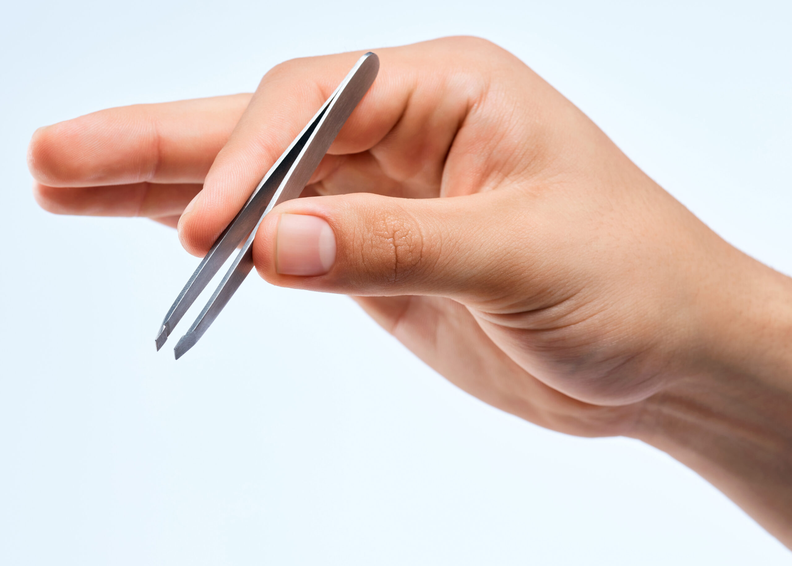 Shot of an unrecognizable man holding a tweezer against a white background.