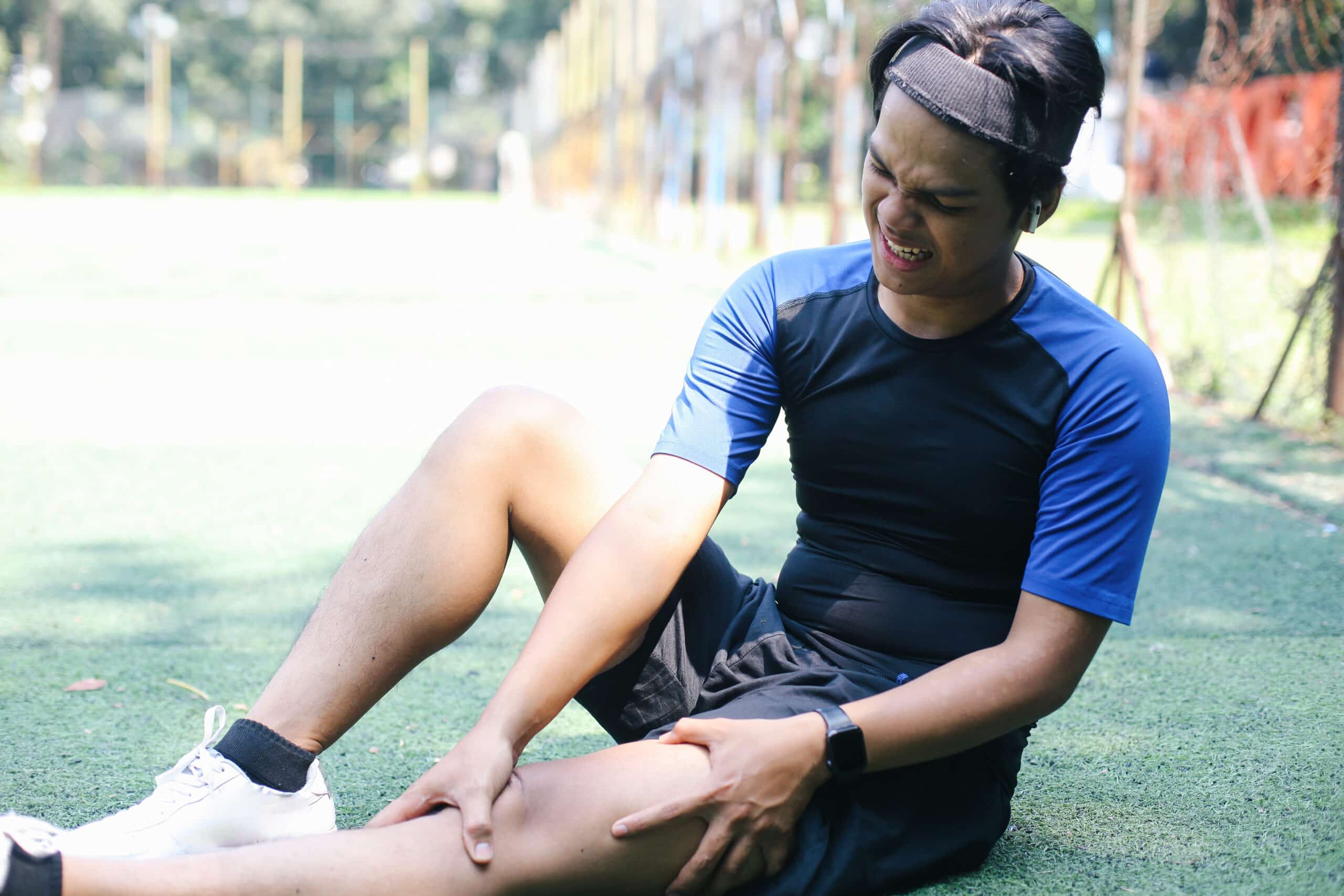 young Asian man with muscle cramps